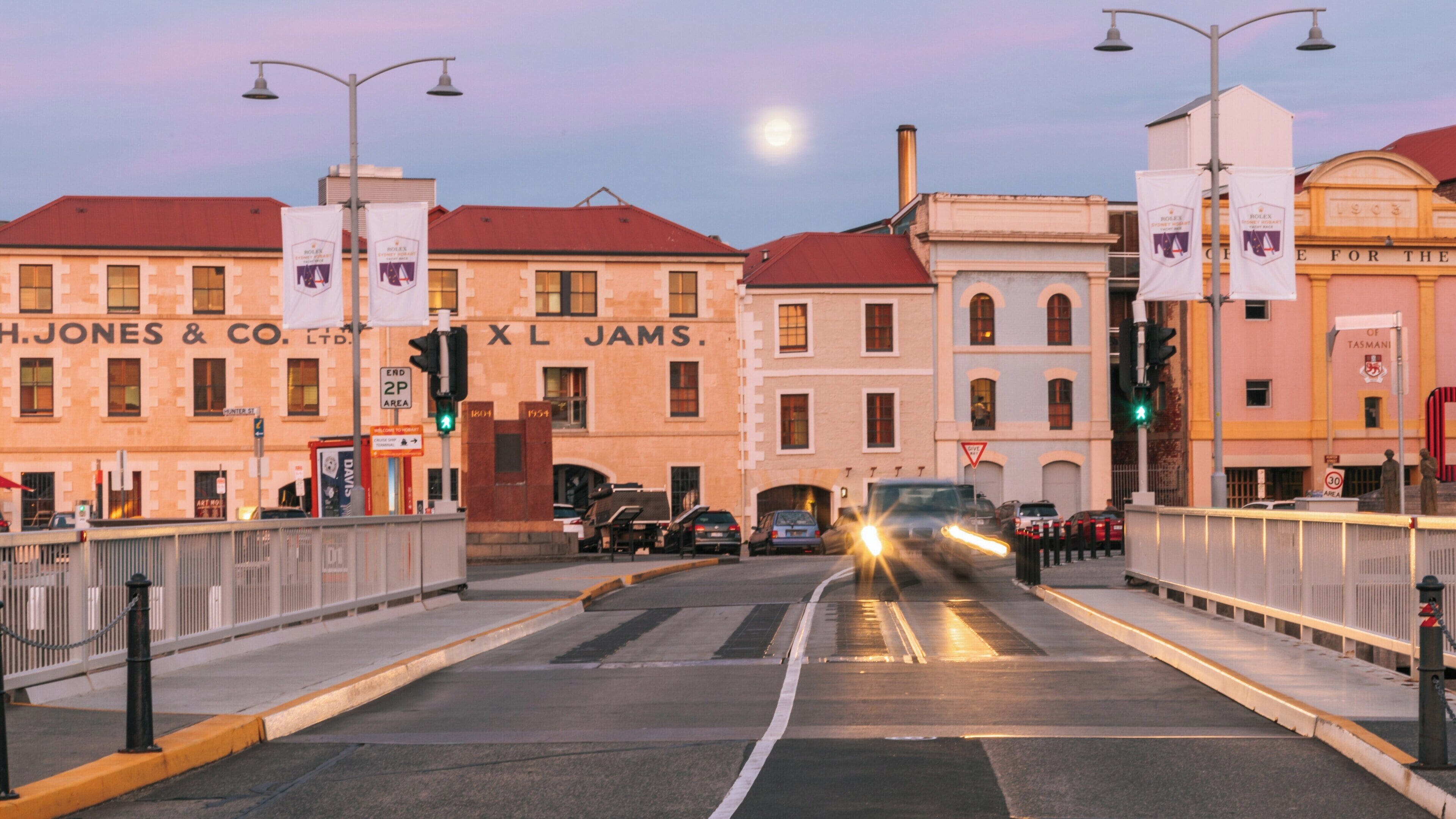 Vibrant evening at Constitution Dock in Hobart, Tasmania showcasing historic buildings under a rising moon