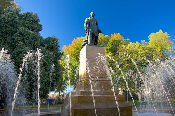 Uma estátua com jatos de água em um parque.