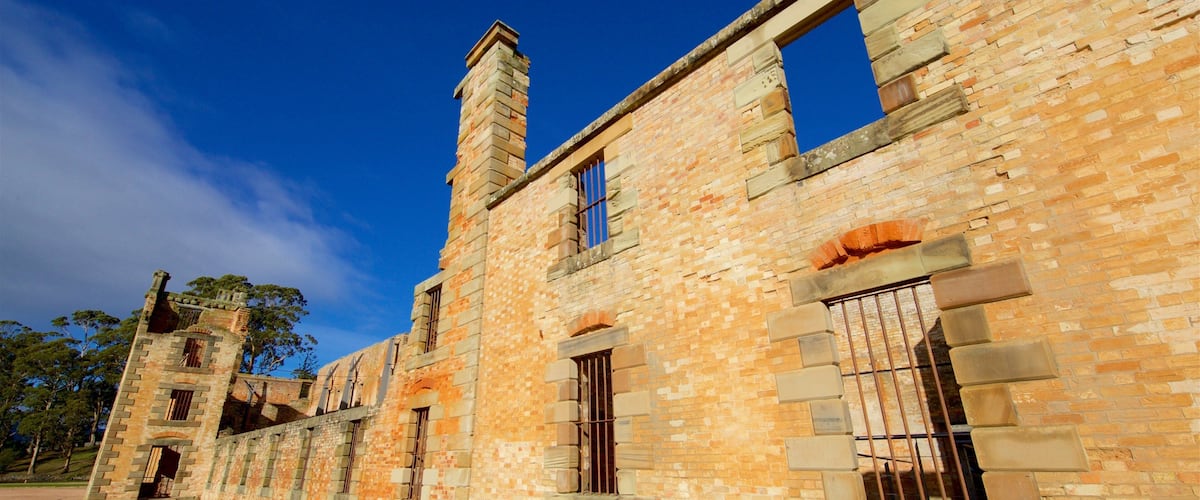 A historic stone building with multiple windows and a chimney.