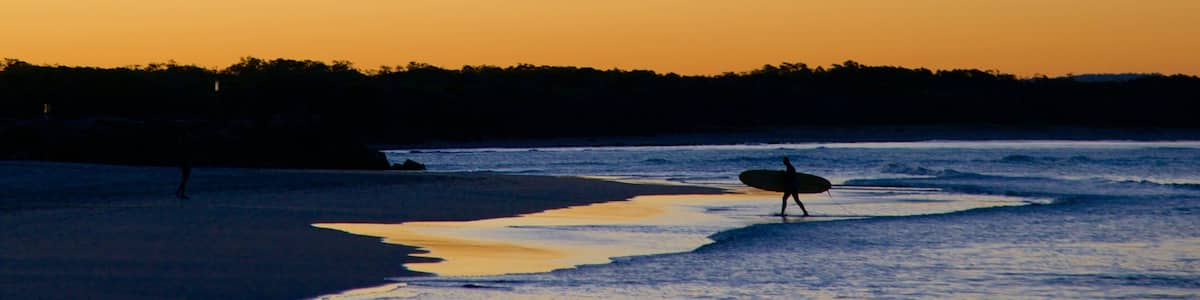 Noosa Beach which includes a beach, a sunset and surfing