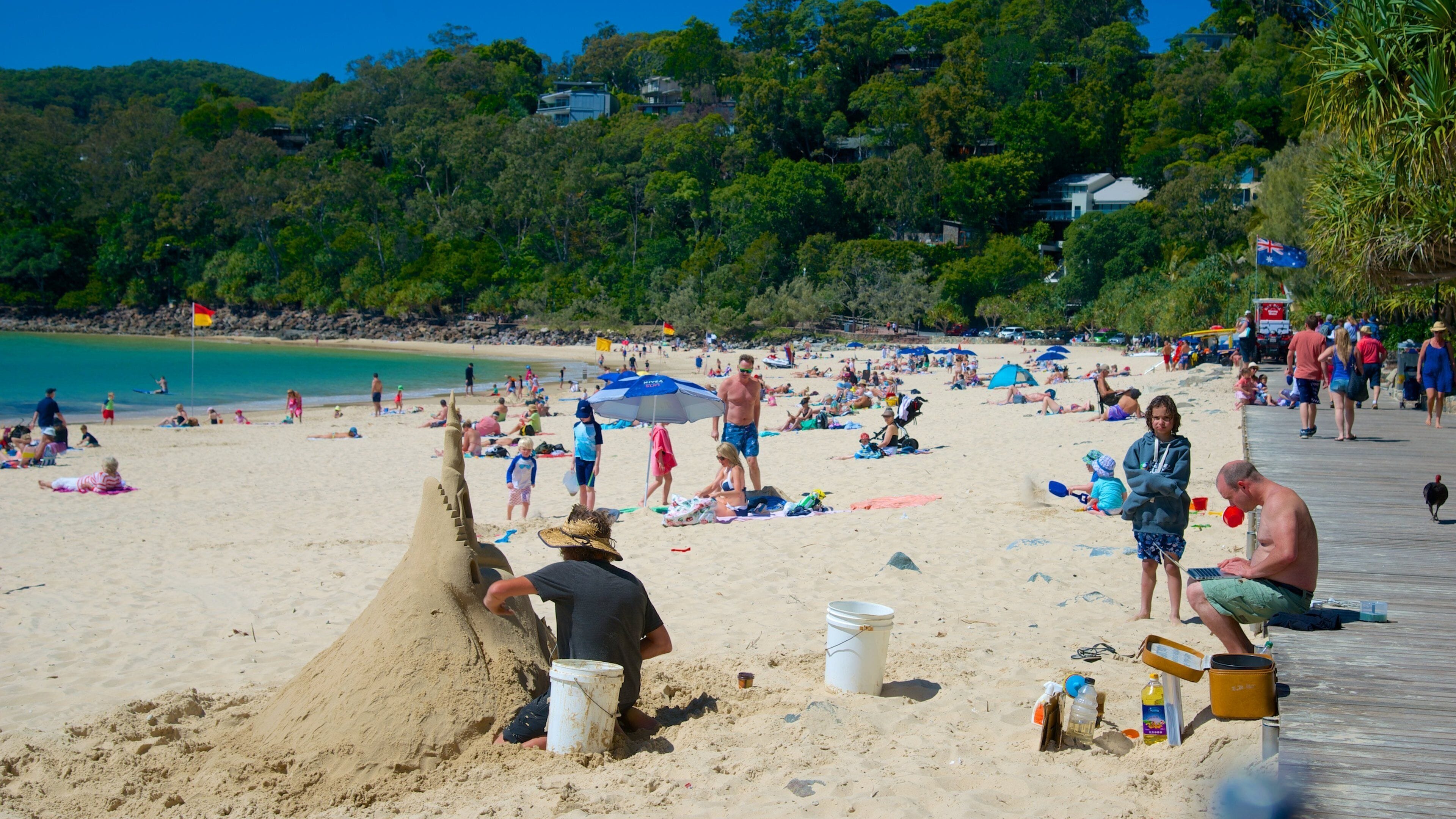 Noosa Beach which includes a beach as well as a large group of people