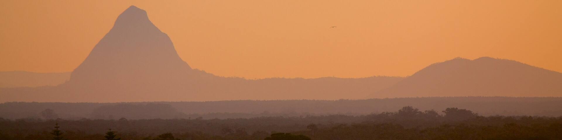 Glasshouse Mountains National Park featuring a sunset, mountains and landscape views
