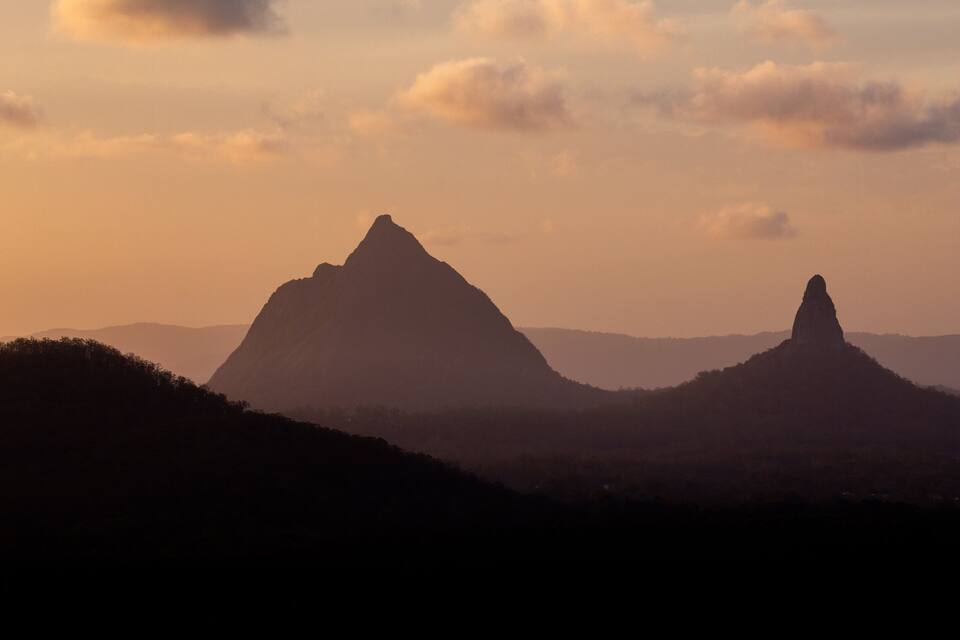 A mountain range with two prominent peaks during sunset.