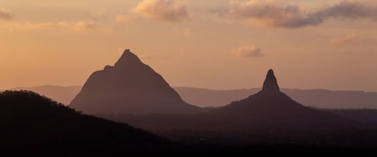 A mountain range with two prominent peaks during sunset.