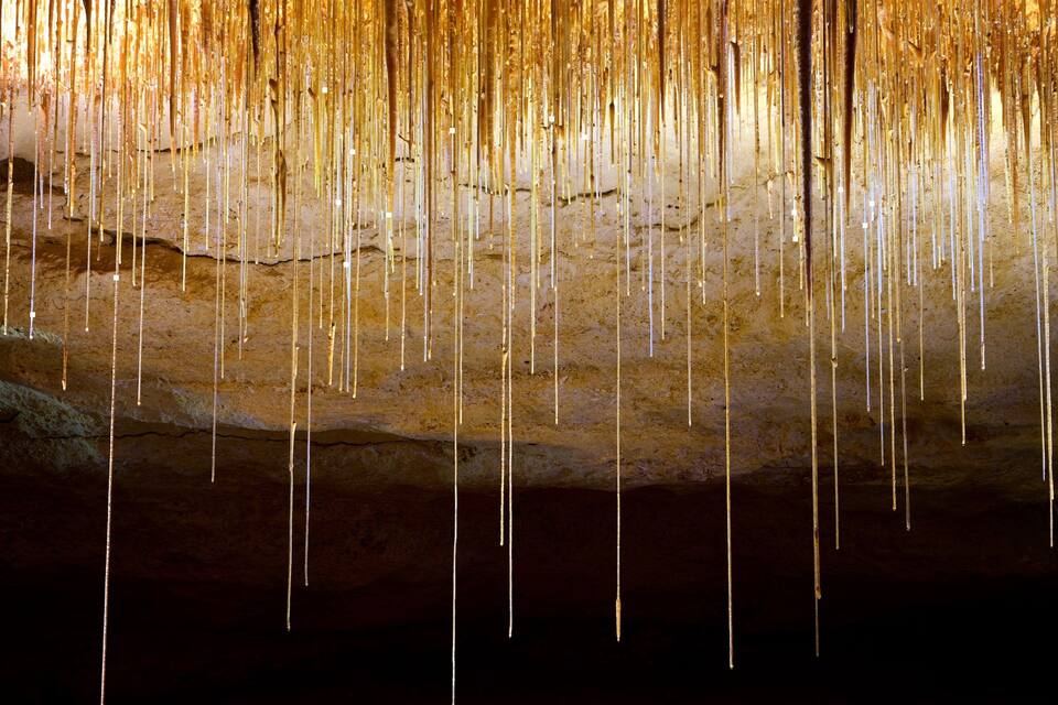 A cave with stalactites hanging from the ceiling.