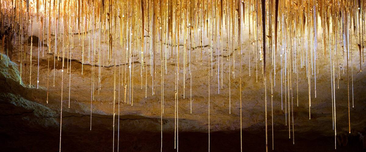 A cave with stalactites hanging from the ceiling.