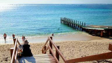 Prevelly Beach featuring a bay or harbor and a sandy beach as well as a small group of people