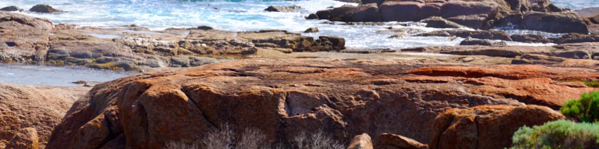 A rocky coastline with waves crashing against the rocks.