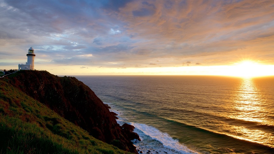 Farol de Cape Byron caracterizando um pôr do sol e litoral rochoso