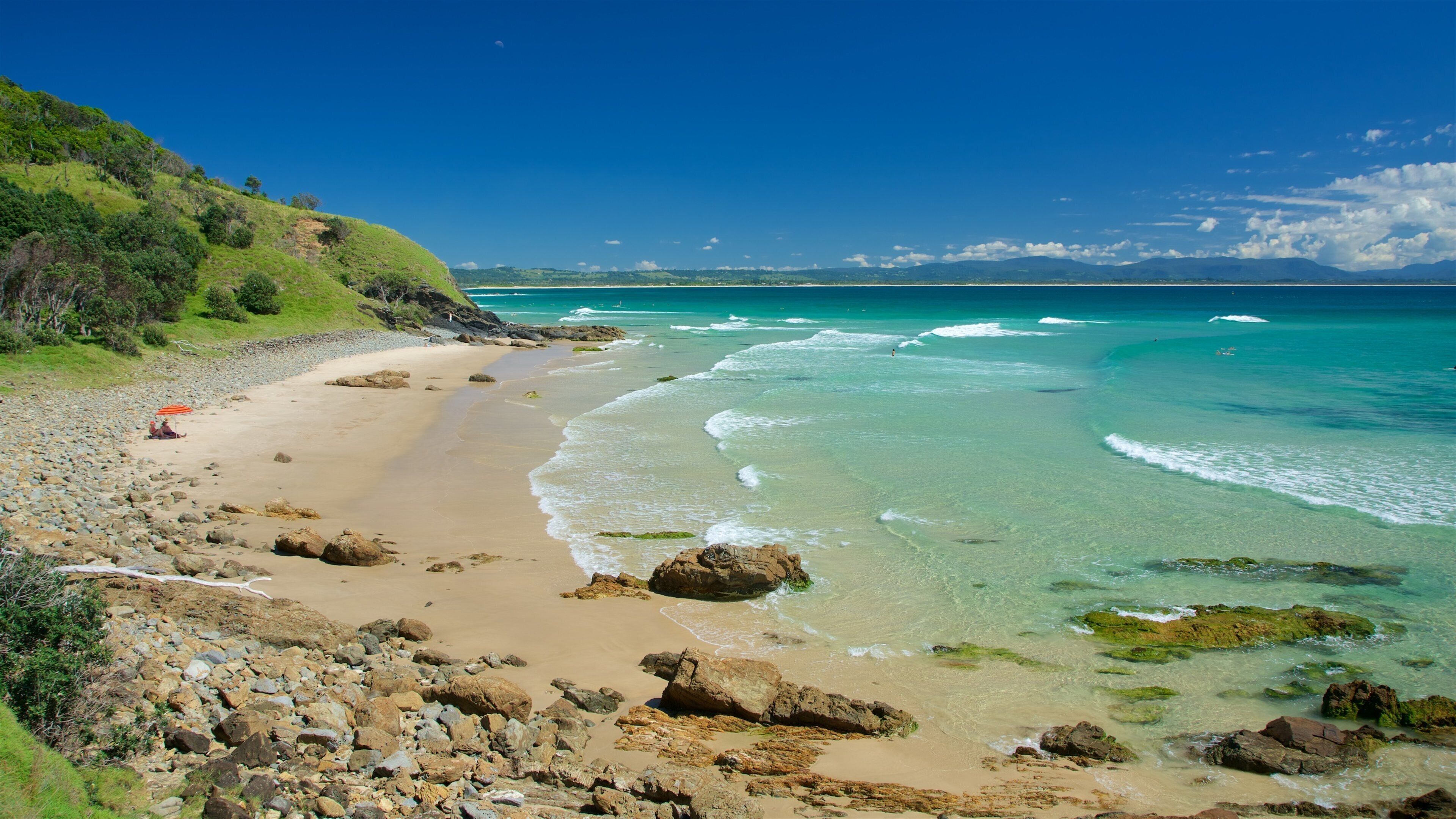 Wategos Beach featuring rugged coastline and a beach