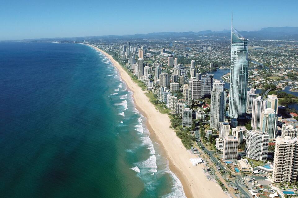 Una ciudad costera con una playa extensa, edificios altos y un río.