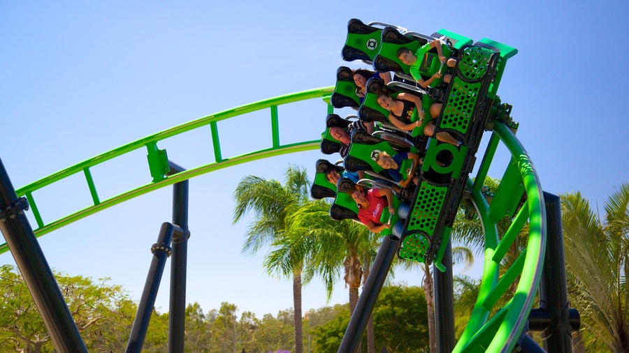 A green roller coaster with passengers.