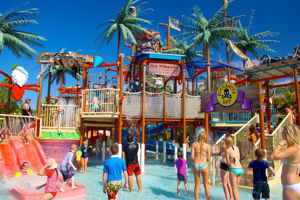 A water park with slides, a pirate-themed play area, and palm trees.