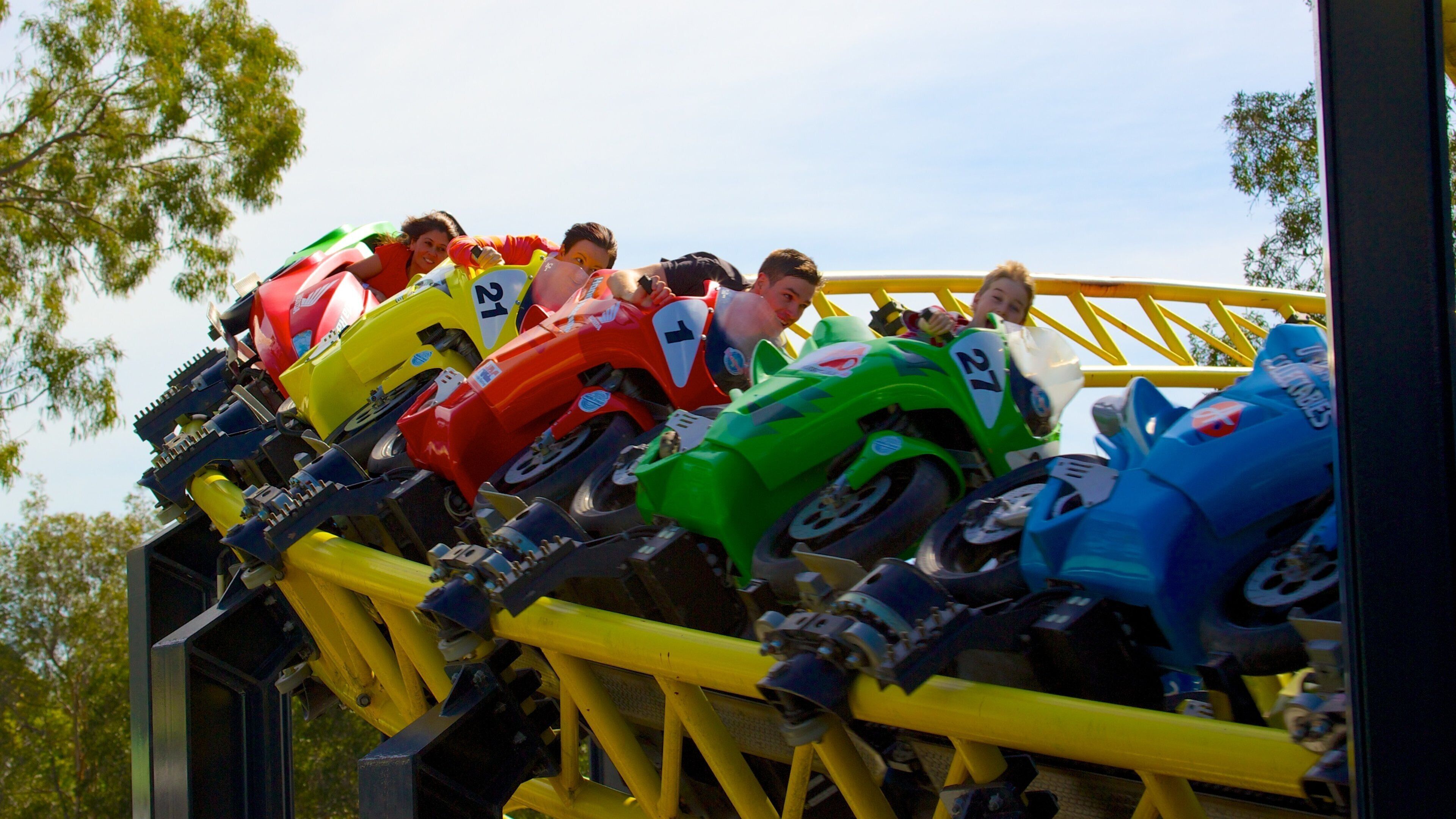A roller coaster with colorful cars numbered 21, 27, and 7.