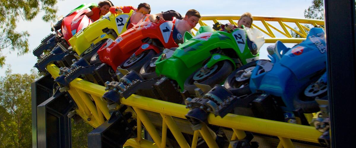 A roller coaster with colorful cars numbered 21, 27, and 7.