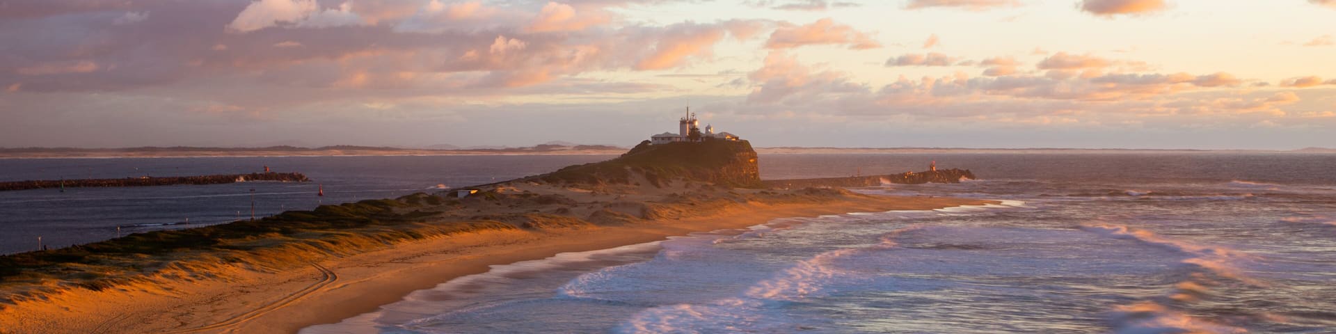 Nobbys Head Beach which includes a sunset and general coastal views
