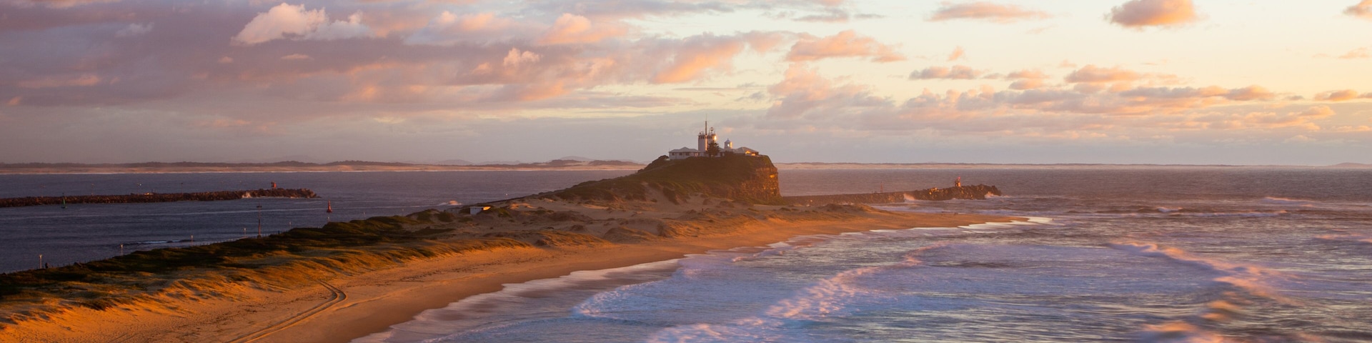 Nobbys Head Beach which includes a sunset and general coastal views