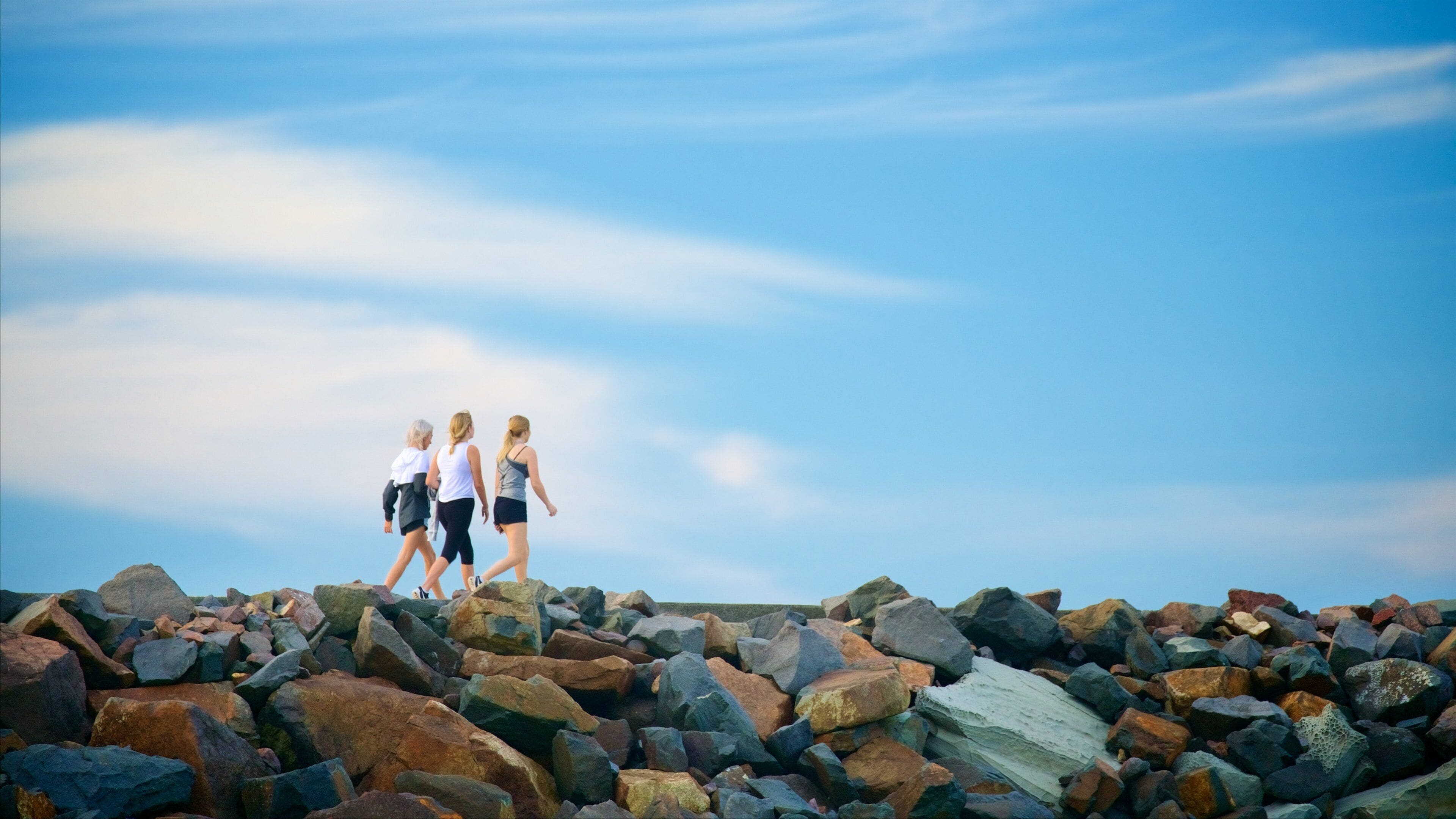Nobbys Head Beach featuring rocky coastline as well as a small group of people