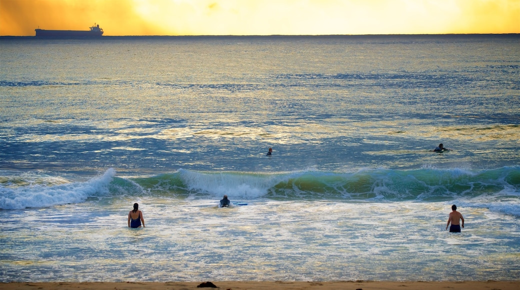 North Wollongong Beach which includes a sandy beach, general coastal views and a sunset