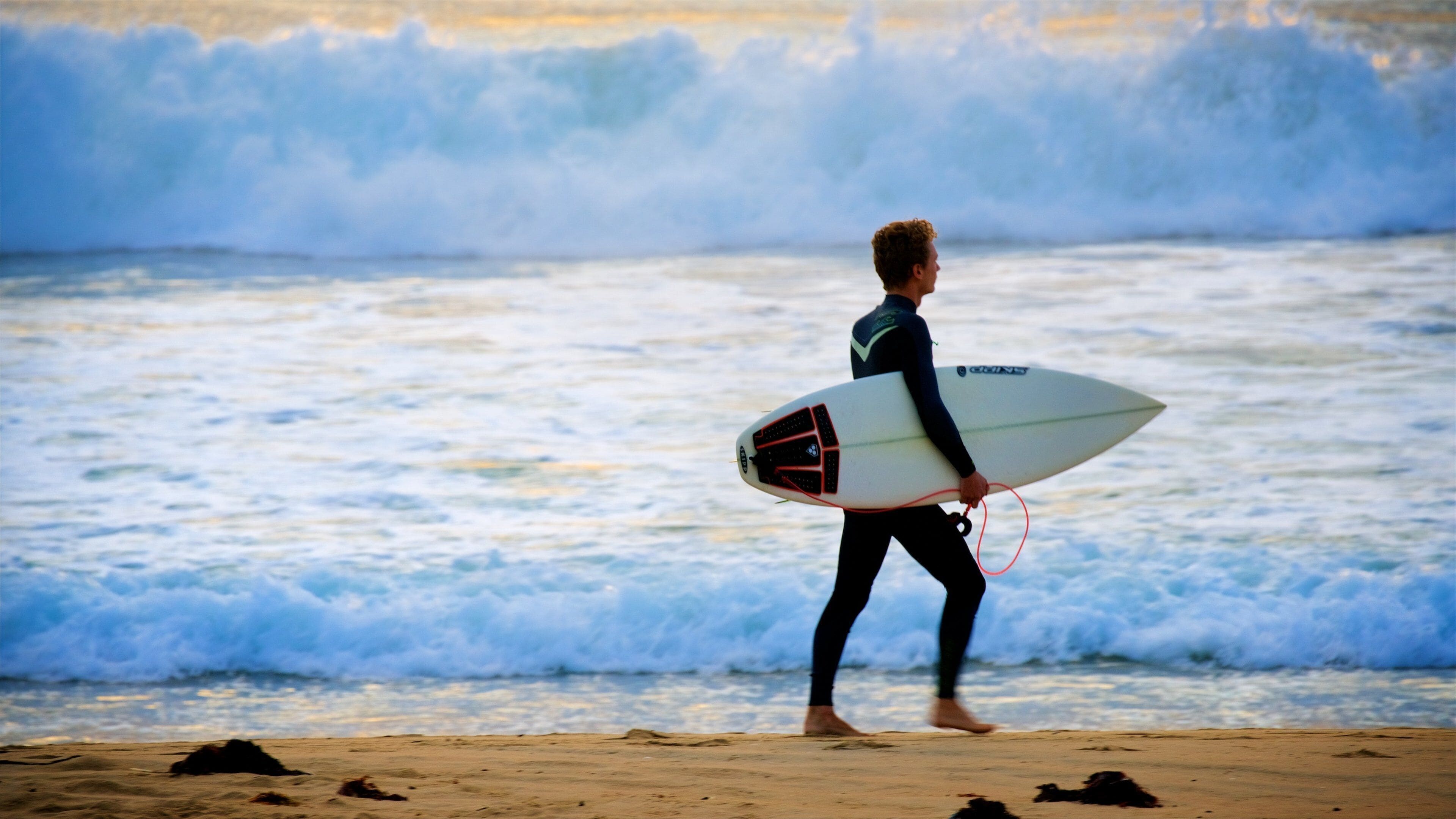 Wollongong North Beach welches beinhaltet Wellen und Sandstrand sowie einzelner Mann