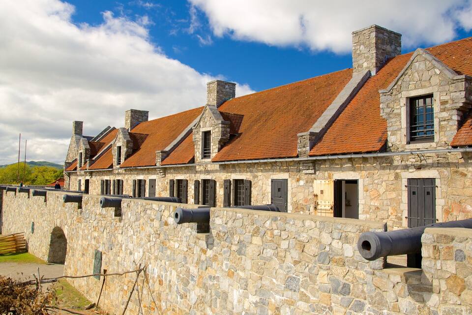 A stone building with red-tiled roofs and multiple cannons.