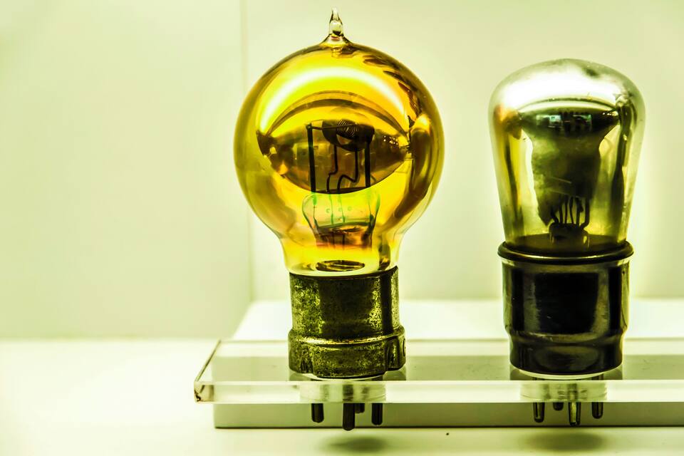 Two vintage light bulbs on a white surface.