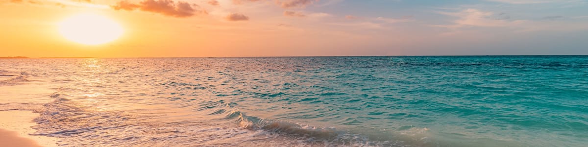 Closeup sea sand beach. Panoramic beach landscape. Inspire tropical beach seascape horizon. Orange and golden sunset sky calmness tranquil relaxing sunlight summer mood. Vacation travel holiday banner