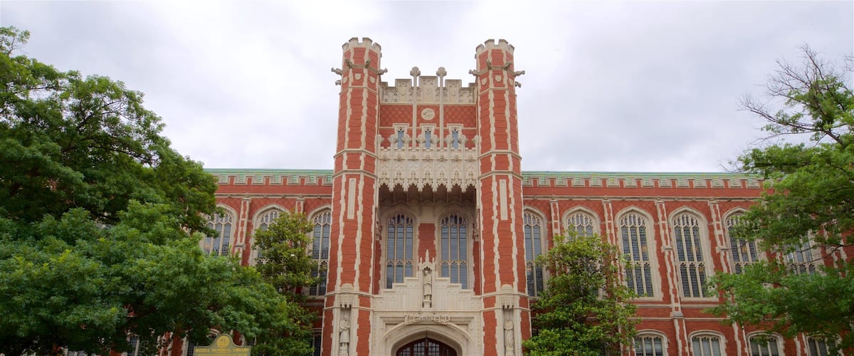 A large red brick building with a central archway and two towers.