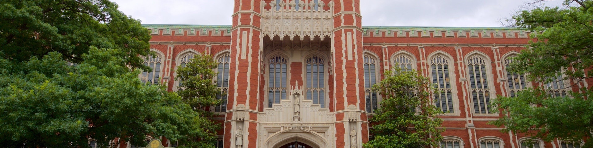 A large red brick building with a central archway and two towers.