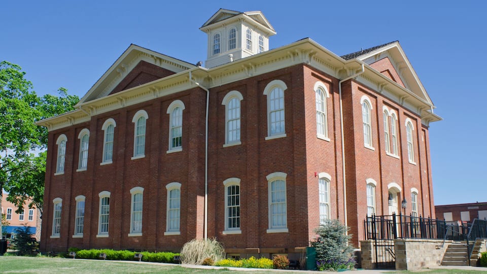 A large red brick building with arched windows and a tower.