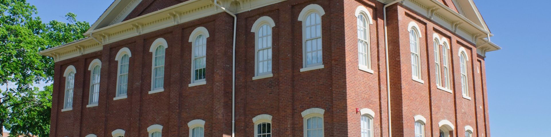 A large red brick building with arched windows and a tower.