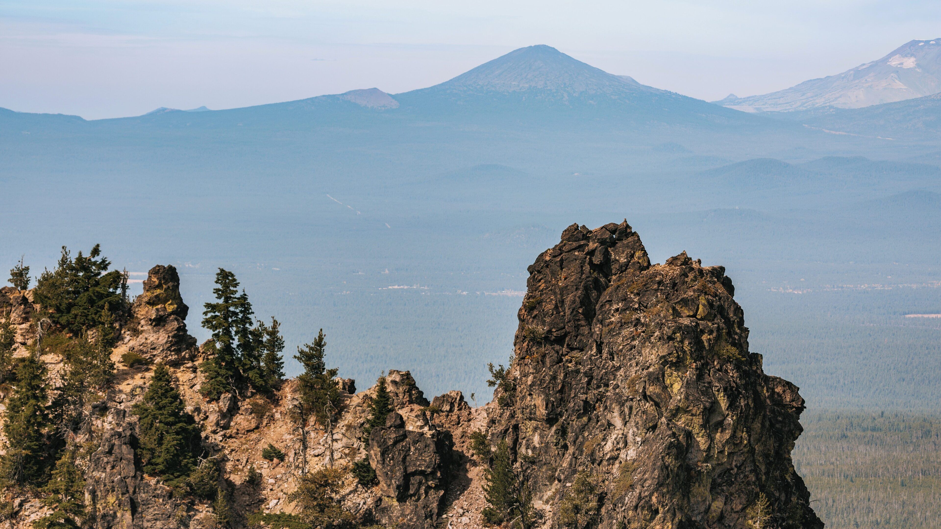 Breathtaking view of rugged formations and distant mountains at Newberry National Volcanic Monument in Bend, Oregon