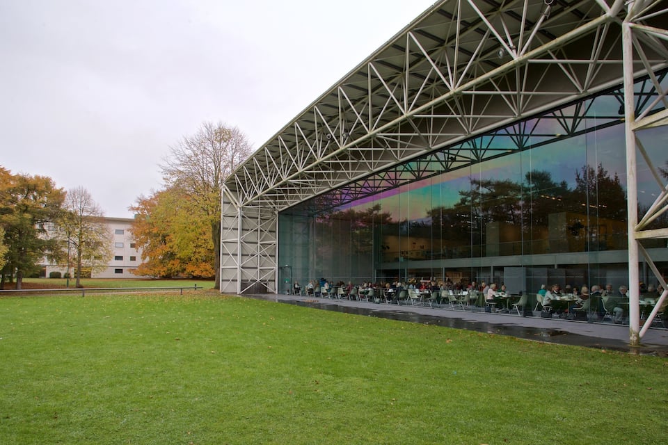 A modern building with a glass facade and a metal framework.