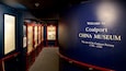Un corridoio con vetrine espositive e una grande parete blu con la scritta 'Welcome to Coalport China Museum'.