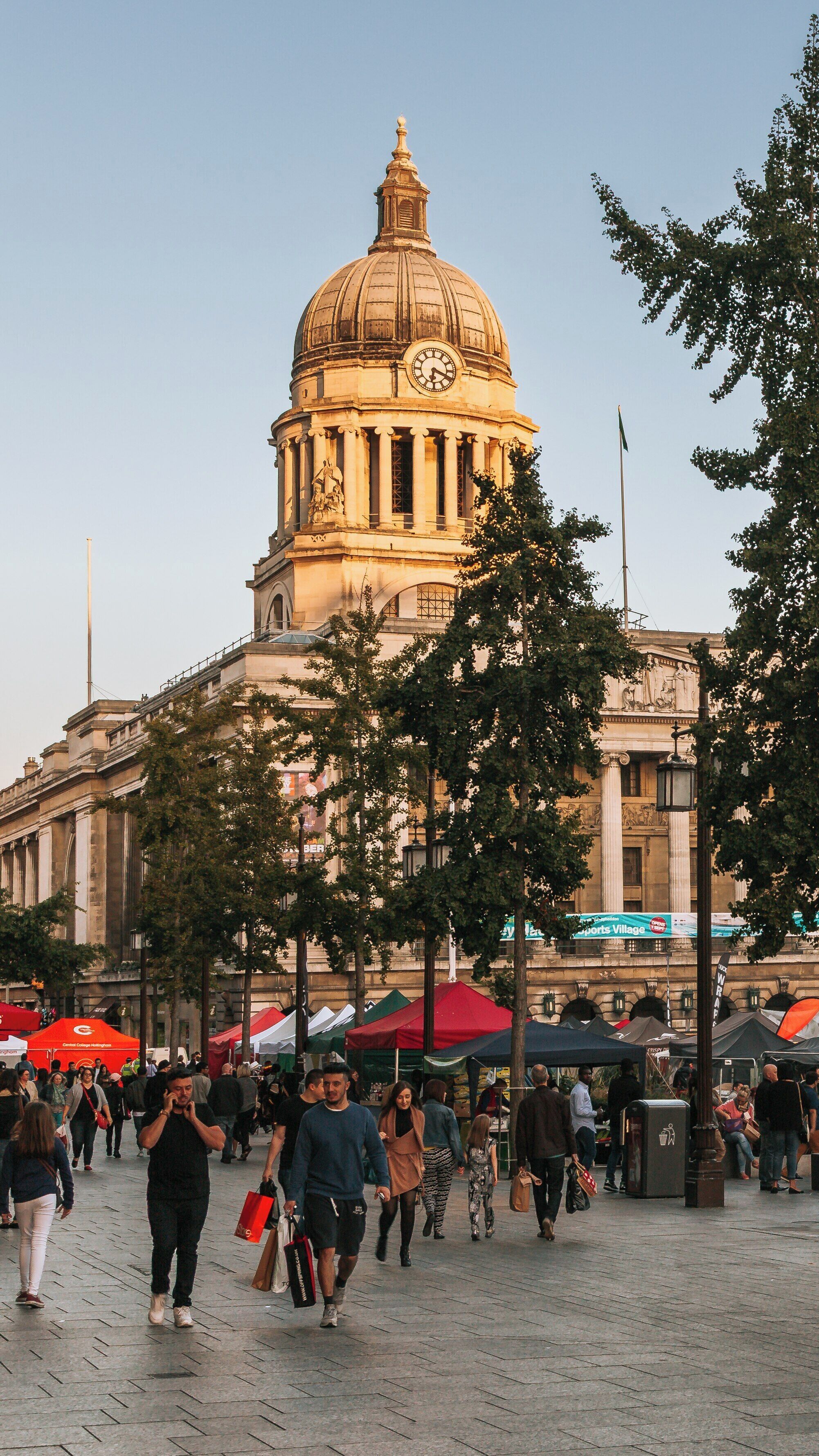 Old Market Square bustling with visitors and vendors in Nottingham City Centre during a pleasant evening