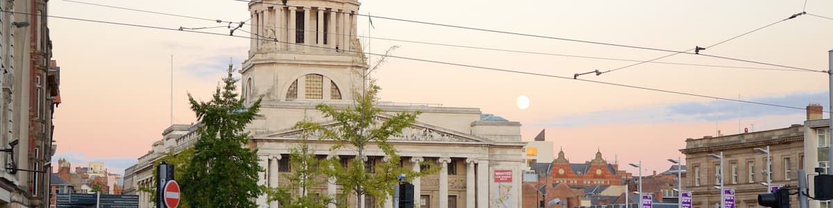A busy street with a large building with a dome in the background.