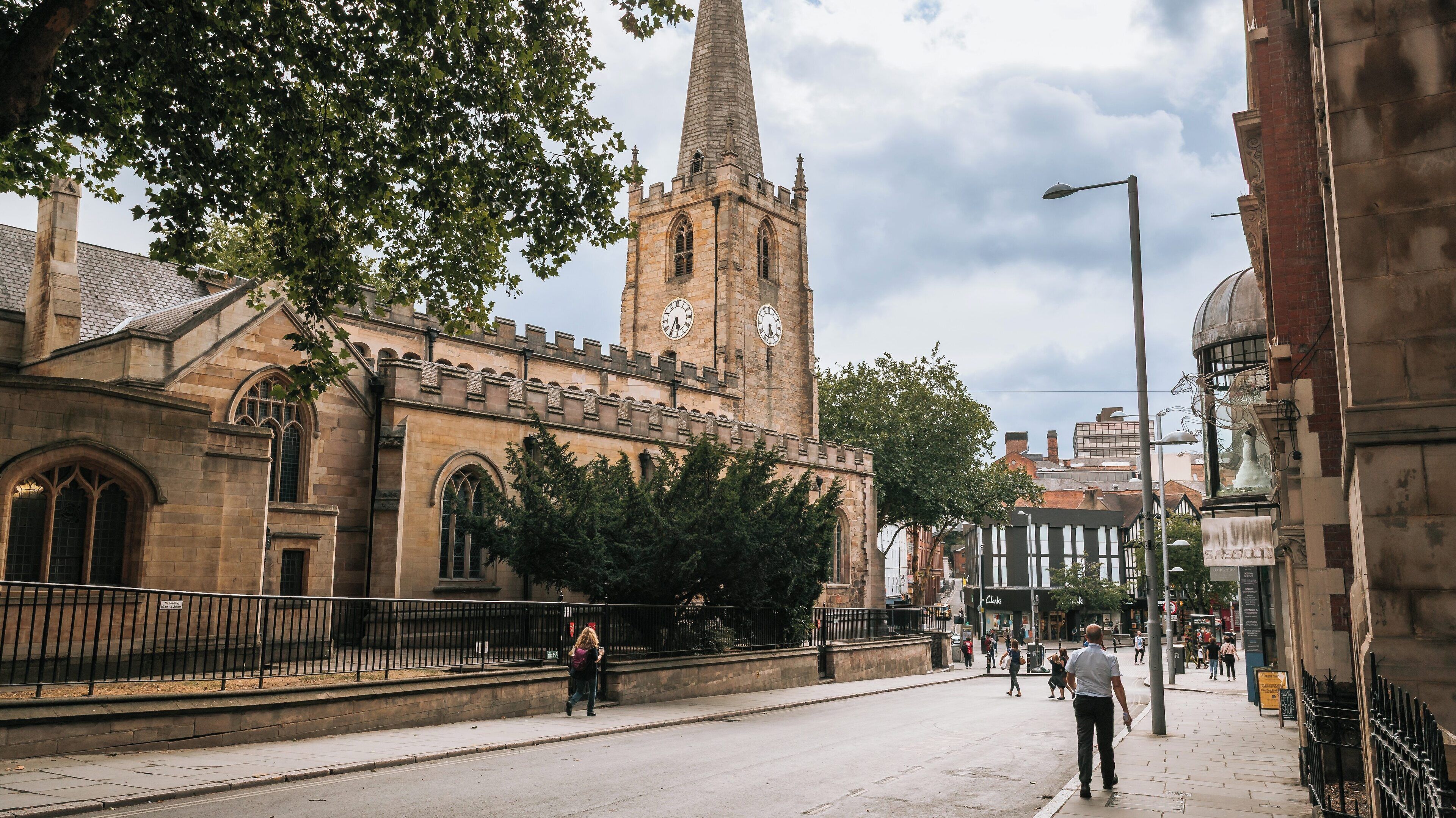 Historic St Peter's Church located in Nottingham City Centre showcasing its stunning architecture and vibrant street life under a cloudy sky