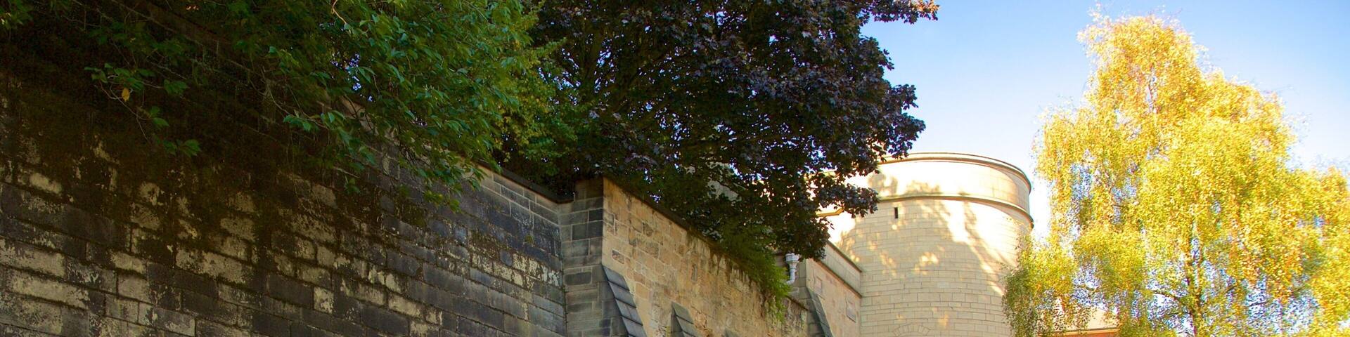 A historic stone building with arched windows and a tower.