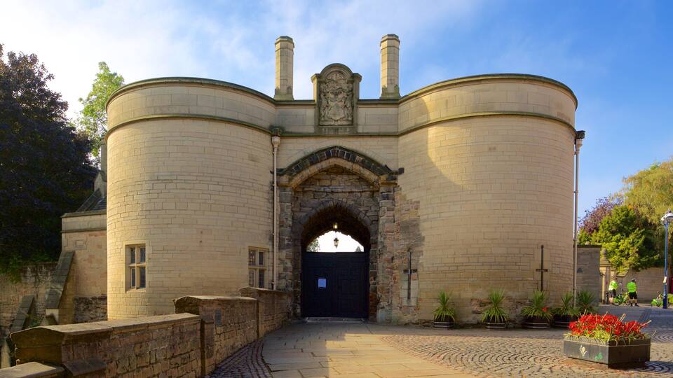 A historic stone building with a central archway and two chimneys.