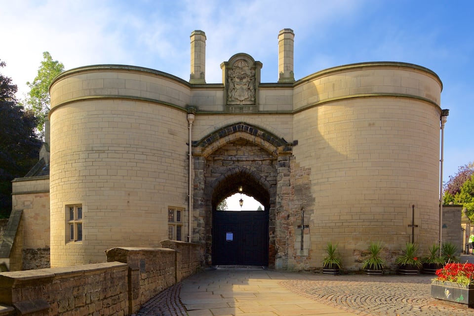A historic stone building with a central archway and two chimneys.