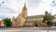 A historic church with a tall spire and a clock tower.