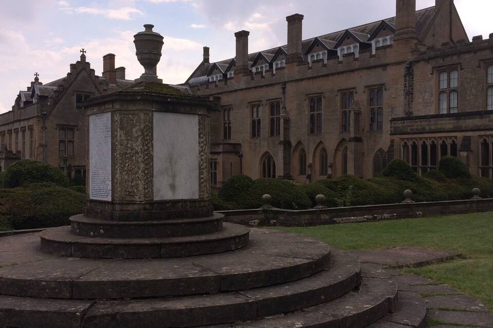 A historic building with a fountain in the foreground.