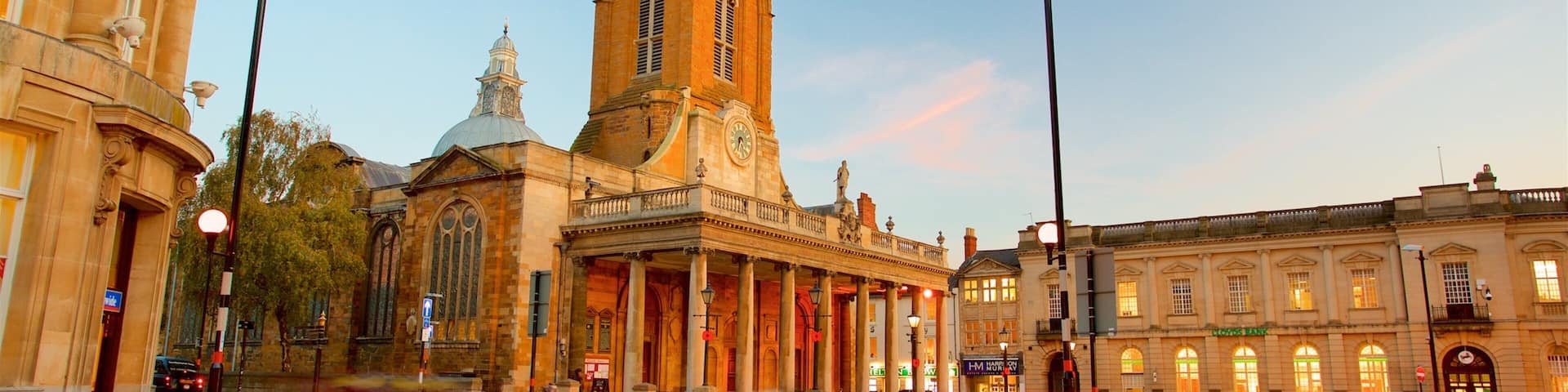 All Saints Church featuring a sunset, a city and heritage architecture