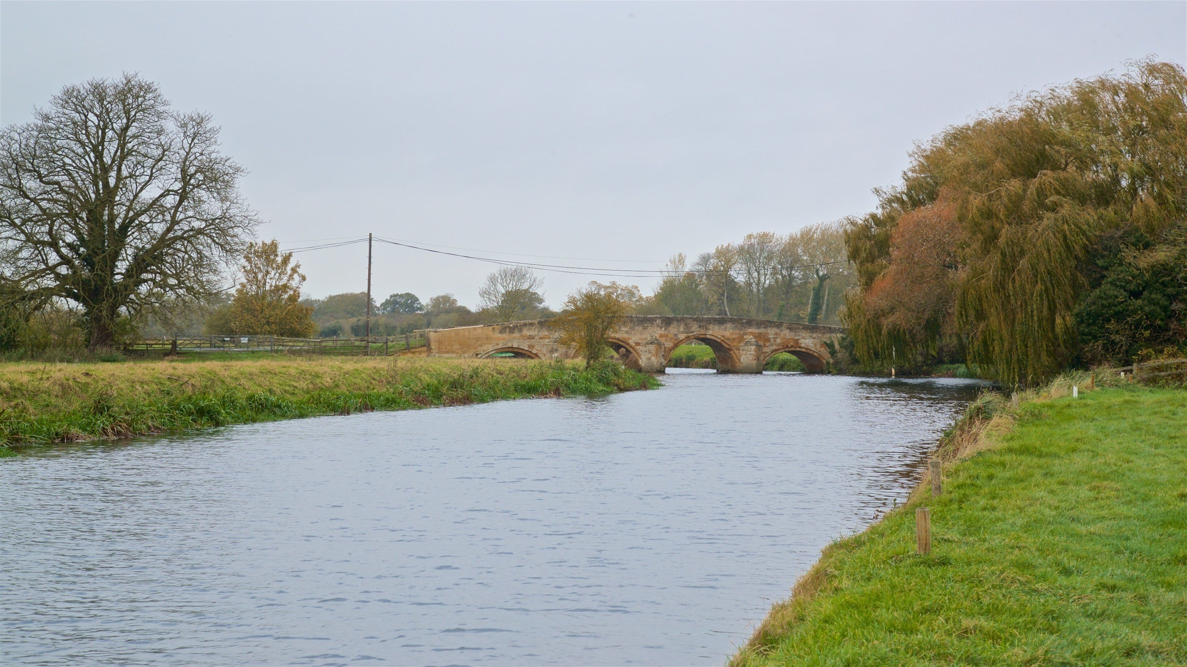 Fotheringhay Castle som visar en bro och en å eller flod
