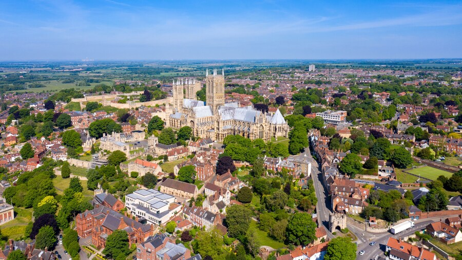 Aerial footage of the Lincoln Cathedral, Lincoln Minster in the UK city centre of Lincoln East Midlands on a bright sunny summers day showing the historic Cathedral Church in the British city centre