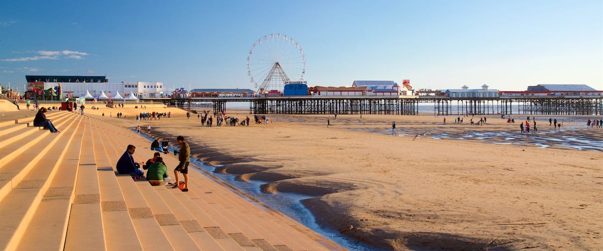 Playa de Blackpool ofreciendo una playa y vista general a la costa y también un pequeño grupo de personas