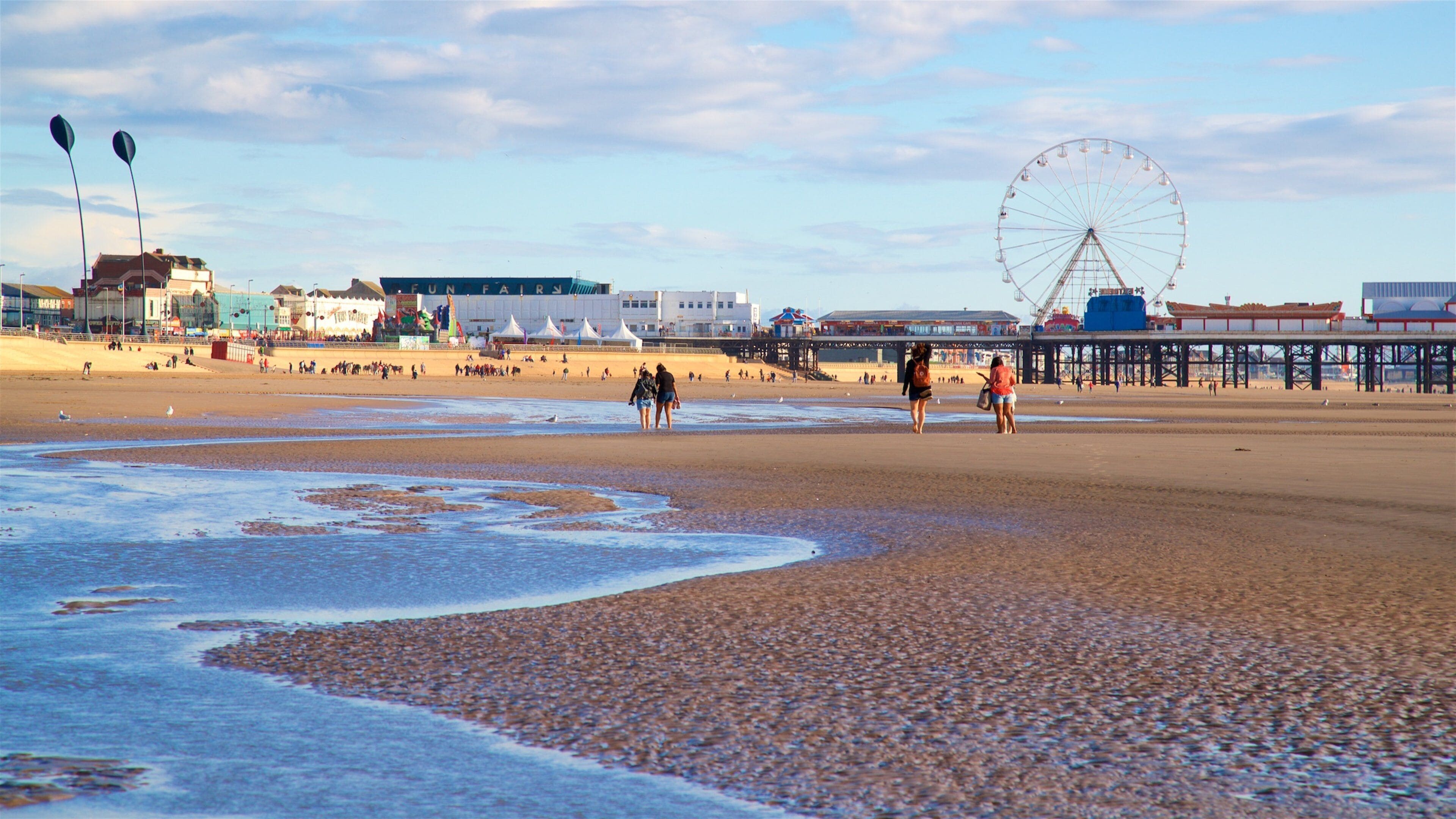 Blackpool Central Pier showing a beach and general coastal views as well as a small group of people