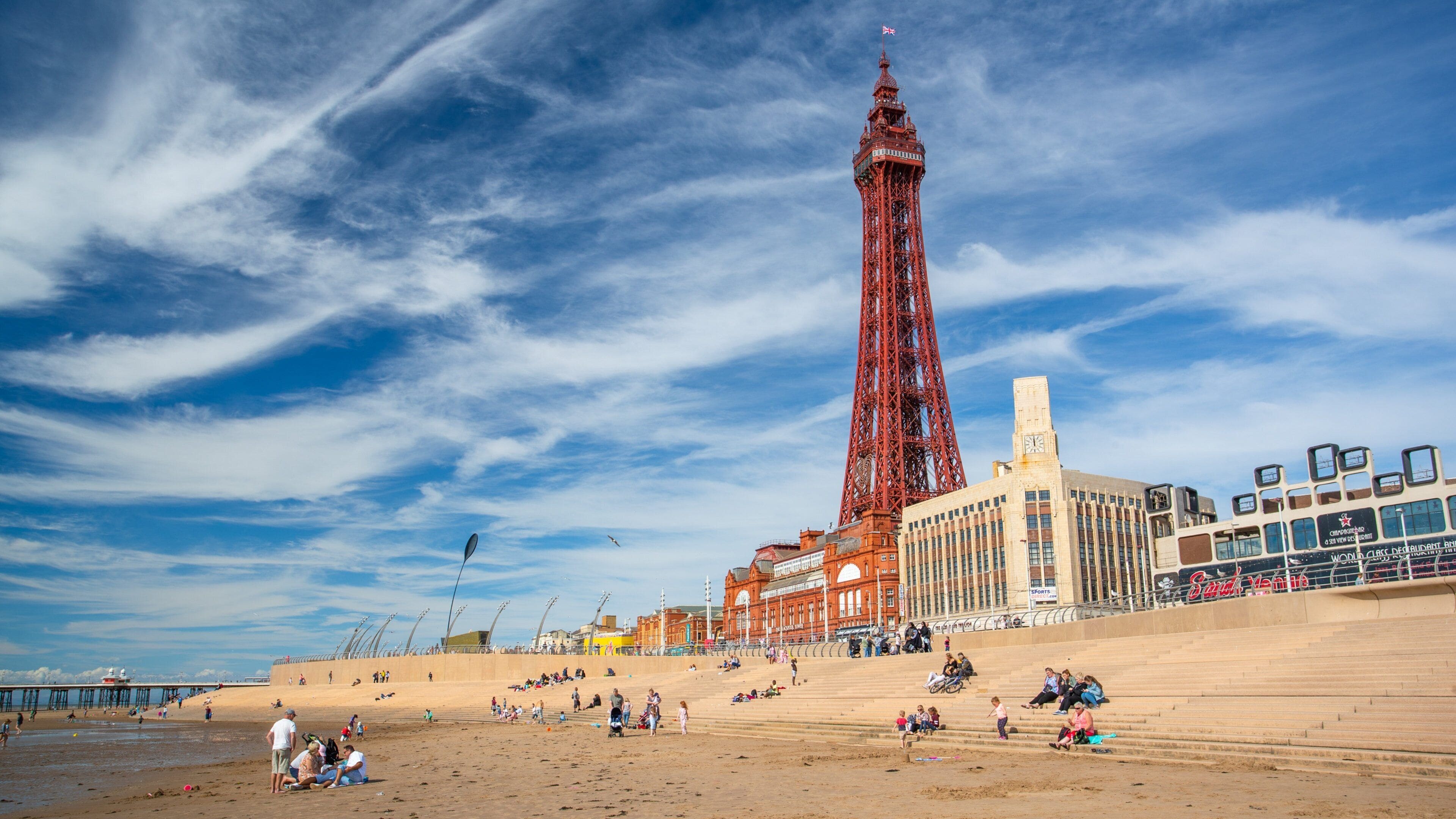 Blackpool Tower which includes a sandy beach, modern architecture and a coastal town