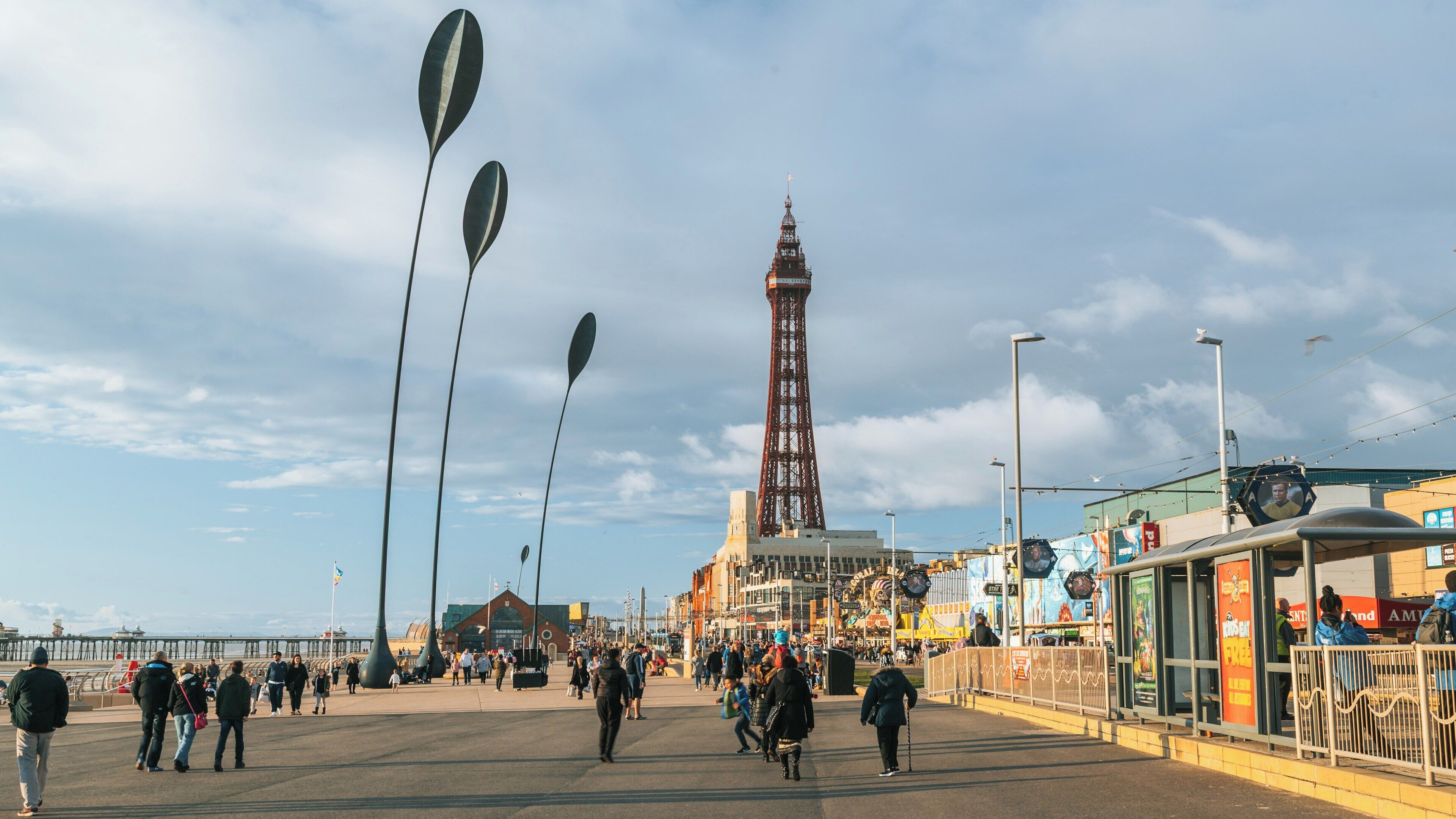 Blackpool Tower stands tall against a vibrant sky in the bustling town center of Blackpool, England, attracting visitors and locals alike
