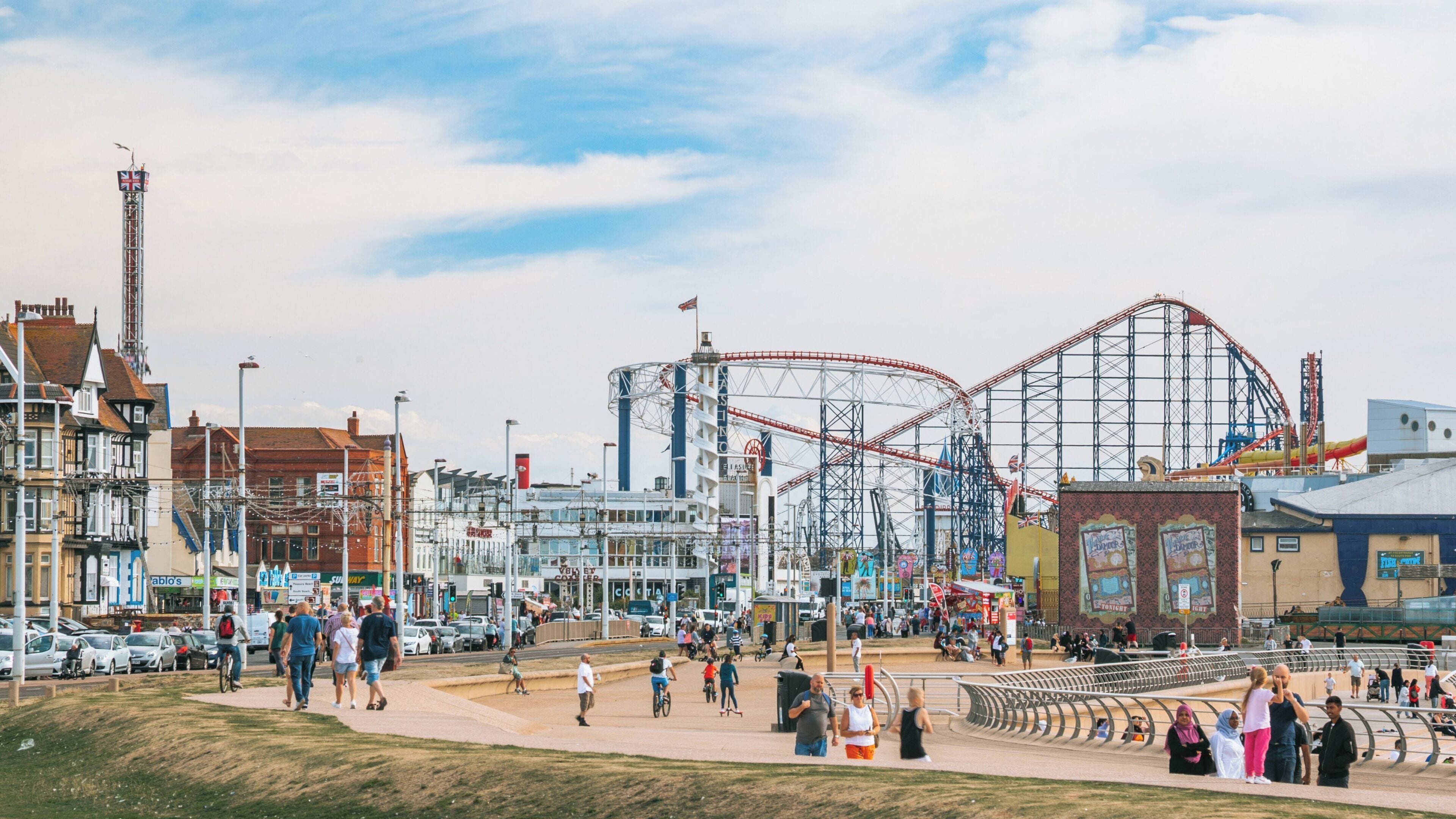Exciting day at Blackpool Pleasure Beach amusement park with roller coasters and cheerful visitors enjoying the South Shore in Blackpool, England